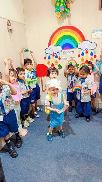 Dream Spire toddlers cheering in front of a rainbow wall display